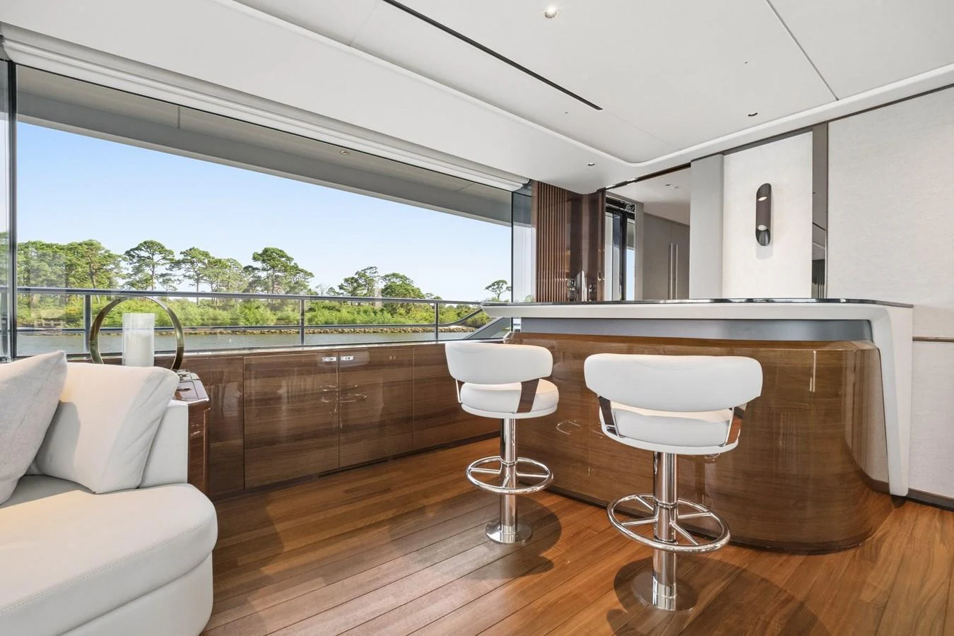 The salon features a sleek bar area with modern stools and large windows offering scenic views. aboard JUST PERFECT Yacht for Sale