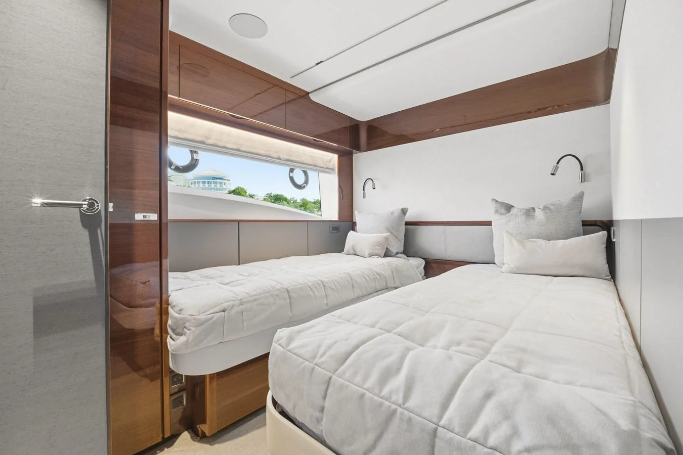 The guest stateroom features two twin beds with plush bedding and a large window for natural light. aboard JUST PERFECT Yacht for Sale