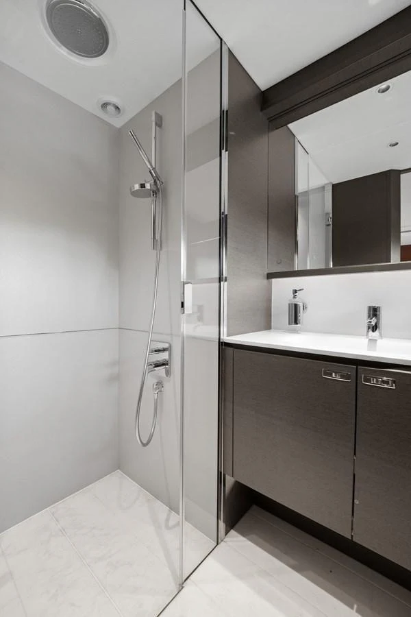 A sleek and modern yacht bathroom with a glass-enclosed shower and contemporary fixtures. aboard JUST PERFECT Yacht for Sale