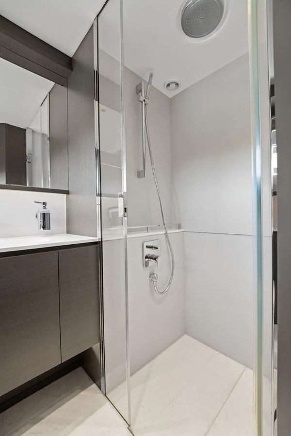 The yacht's bathroom features a sleek, modern design with a glass-enclosed shower and contemporary fixtures. aboard JUST PERFECT Yacht for Sale