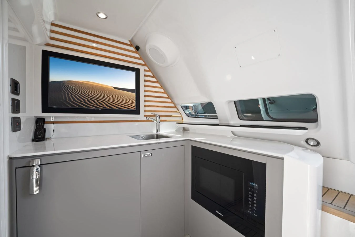 The yacht's galley is modern and well-equipped, featuring sleek cabinetry and a built-in microwave. aboard JUST PERFECT Yacht for Sale