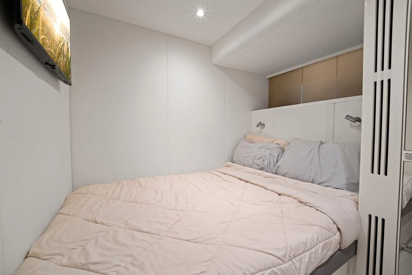 The guest stateroom features a cozy bed with soft bedding and modern lighting. aboard JUST PERFECT Yacht for Sale