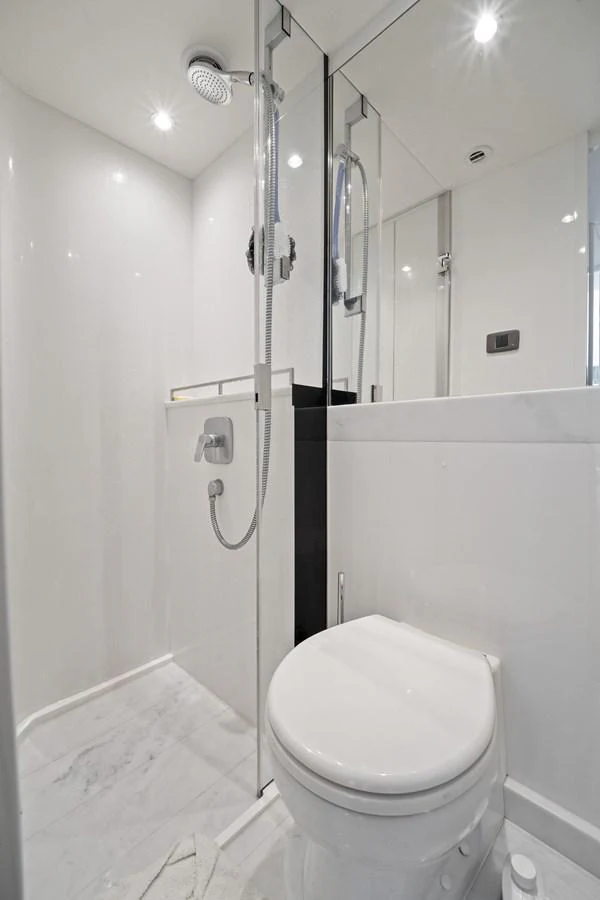 A sleek and modern yacht bathroom featuring a shower and toilet with elegant fixtures. aboard JUST PERFECT Yacht for Sale