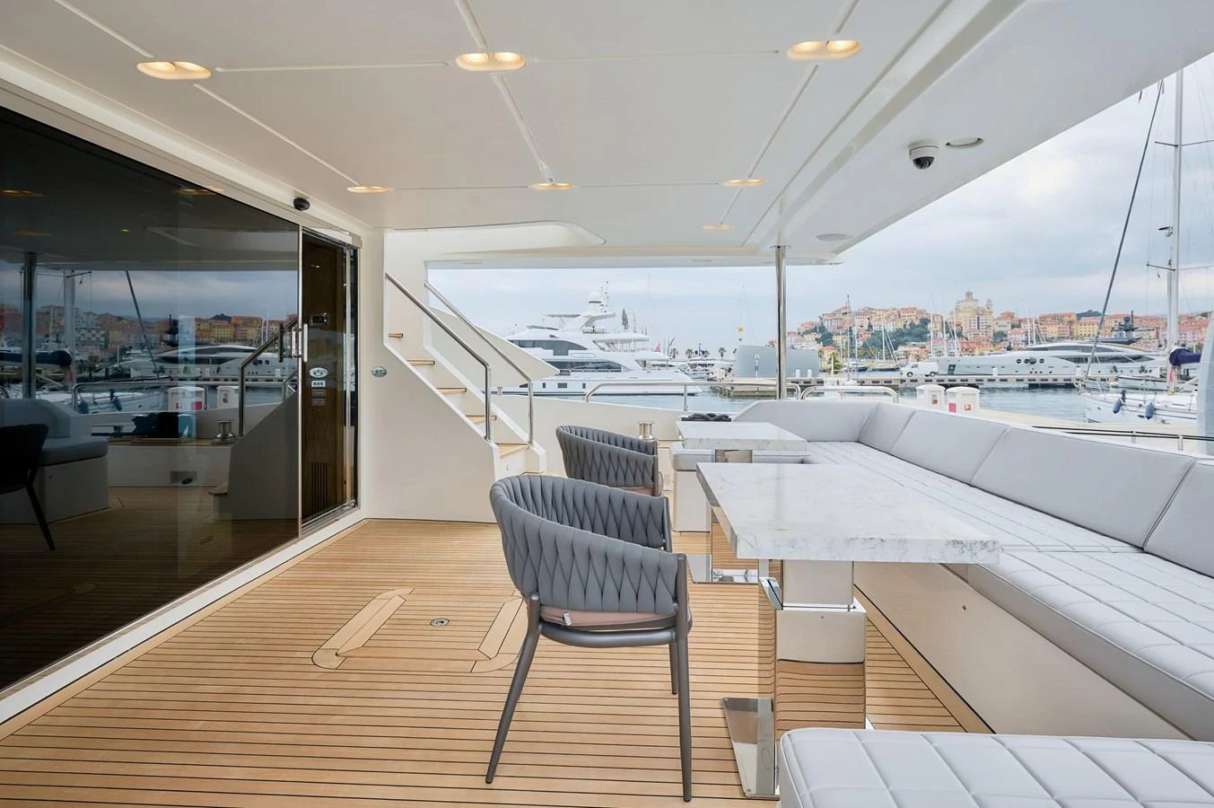 The aft deck features a spacious seating area with a sleek dining table, perfect for alfresco dining. aboard SUN & SEA Yacht for Sale
