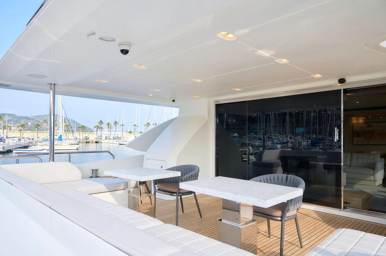 The aft deck features a comfortable seating area with modern tables and chairs, perfect for outdoor relaxation. aboard SUN & SEA Yacht for Sale