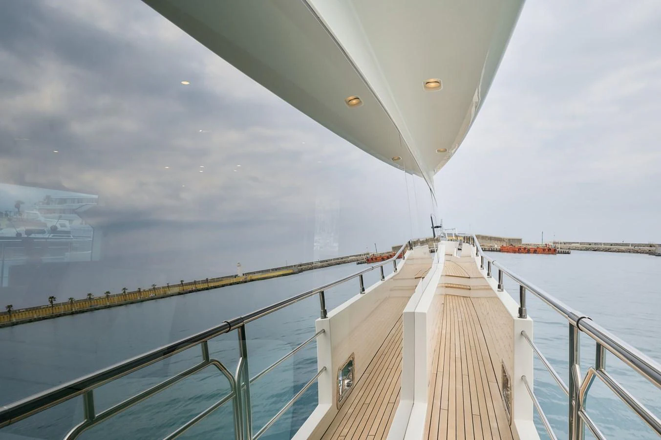 The sleek deck of the yacht offers a stunning view of the calm waters and harbor. aboard SUN & SEA Yacht for Sale