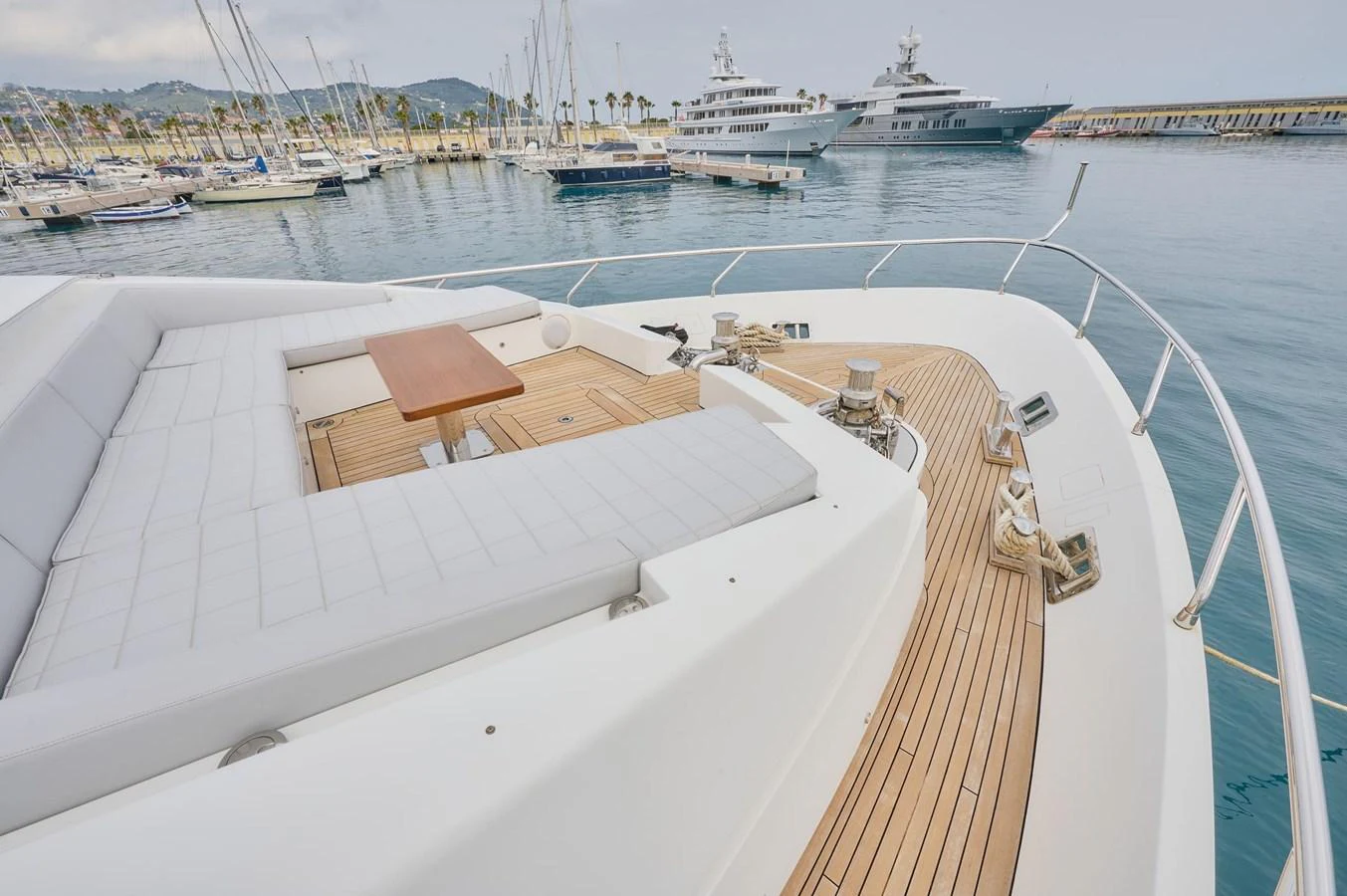 The yacht's foredeck features a spacious seating area with a wooden table, perfect for relaxation and enjoying the view. aboard SUN & SEA Yacht for Sale