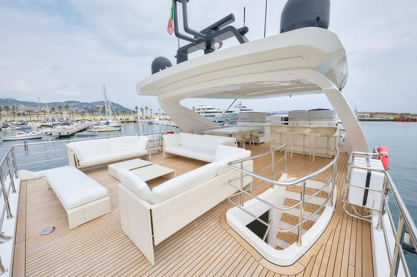 The spacious flybridge offers ample seating and a luxurious lounging area with a stunning view of the marina. aboard SUN & SEA Yacht for Sale