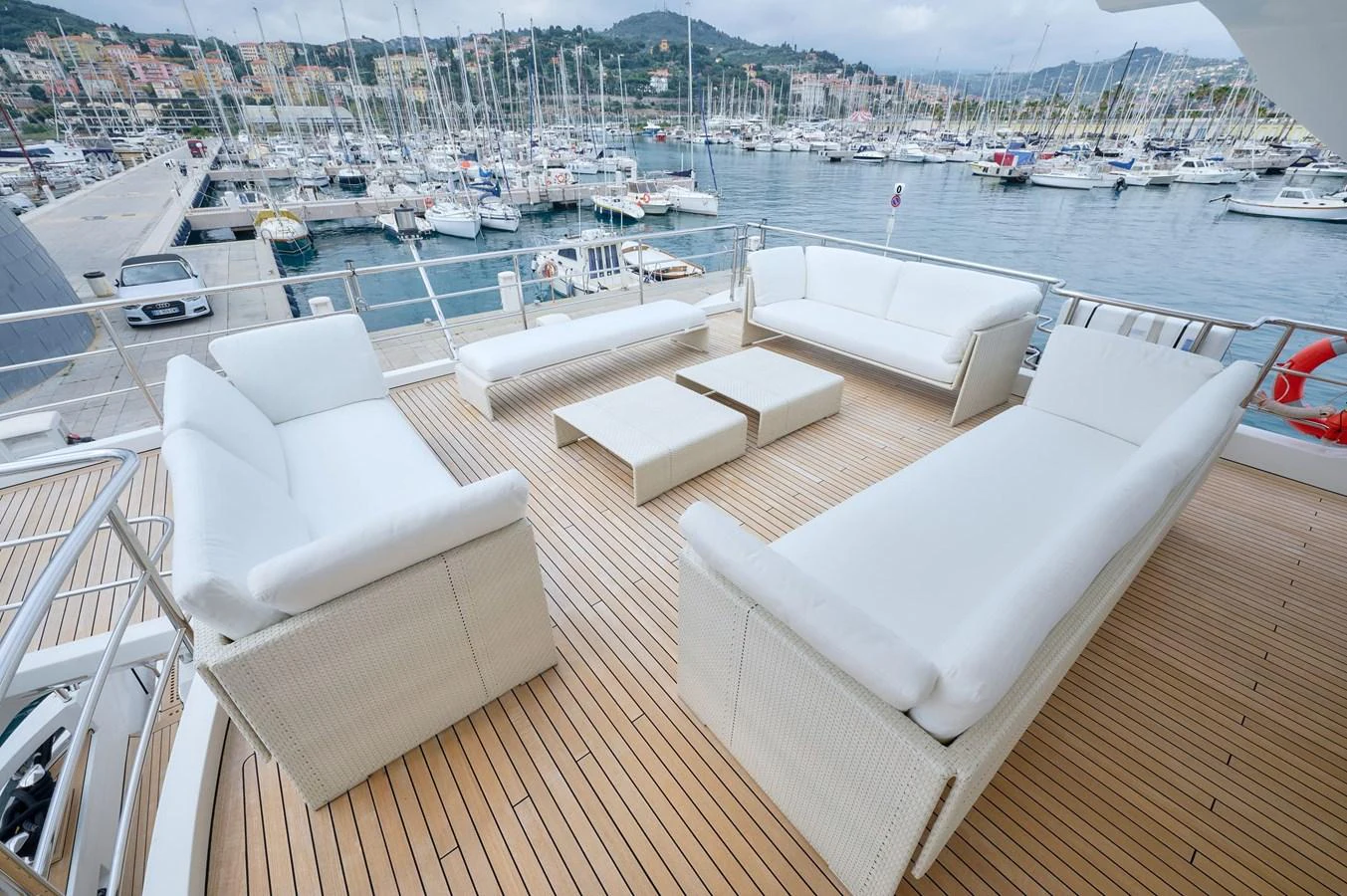 The aft deck features luxurious white seating with a stunning marina view. aboard SUN & SEA Yacht for Sale