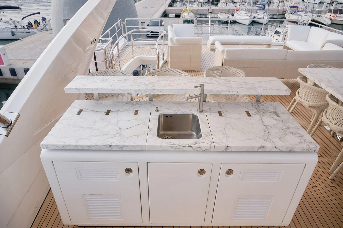 The flybridge features a sleek bar area with a marble countertop and a built-in sink, perfect for outdoor entertaining. aboard SUN & SEA Yacht for Sale