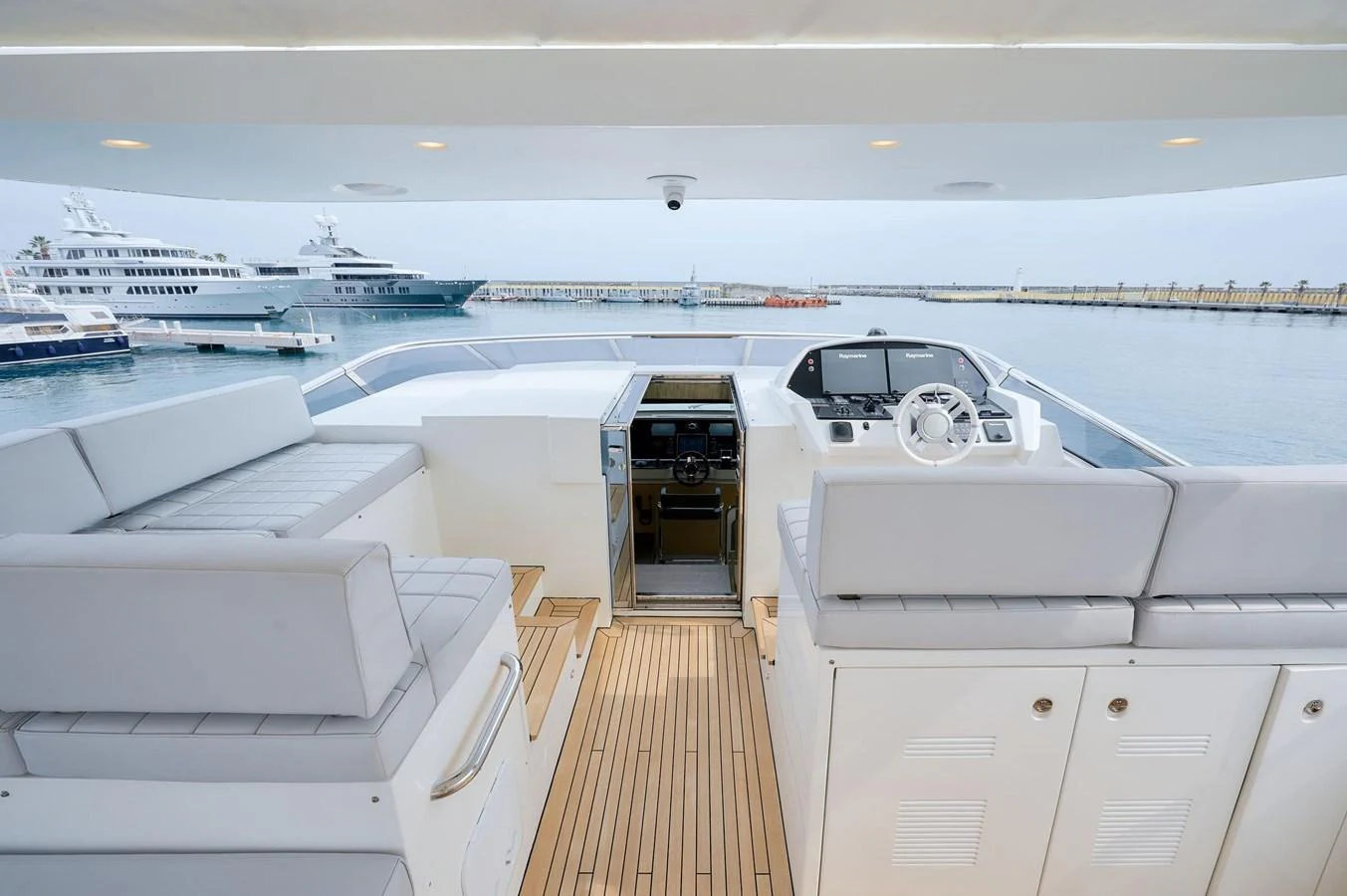 The flybridge offers a spacious and modern area for relaxation and navigation with a stunning view of the marina. aboard SUN & SEA Yacht for Sale