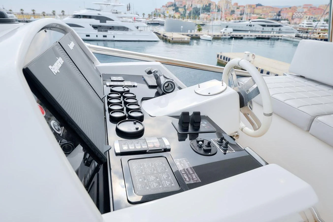 The helm station features advanced navigation controls and a comfortable seating area, overlooking a marina filled with other yachts. aboard SUN & SEA Yacht for Sale