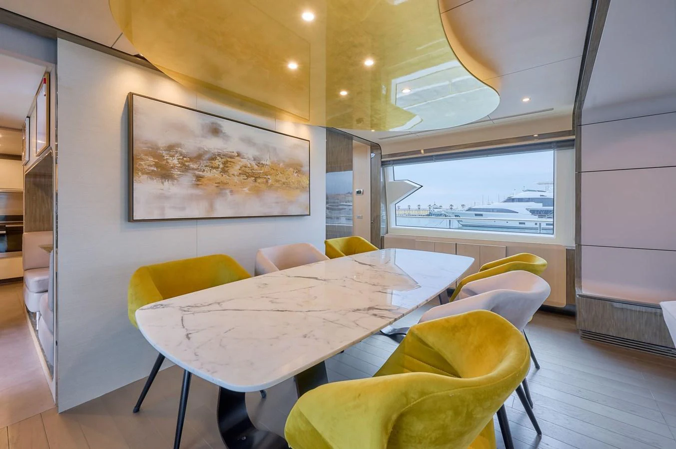 The yacht's dining area features a sleek marble table surrounded by plush chairs, with large windows offering a view of the marina. aboard SUN & SEA Yacht for Sale