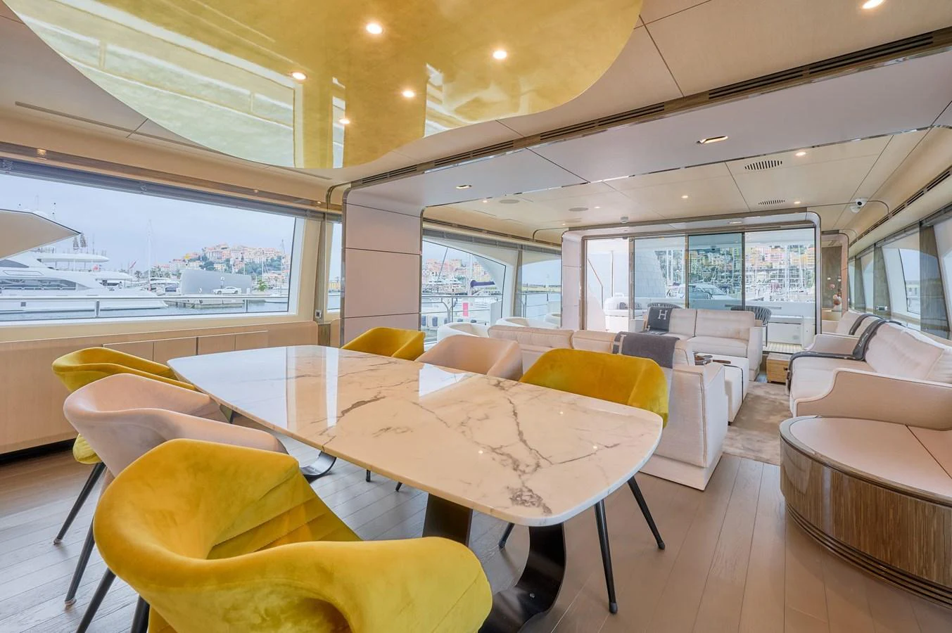 The yacht's salon features a luxurious dining area with a marble table and plush seating, complemented by large windows offering stunning views. aboard SUN & SEA Yacht for Sale
