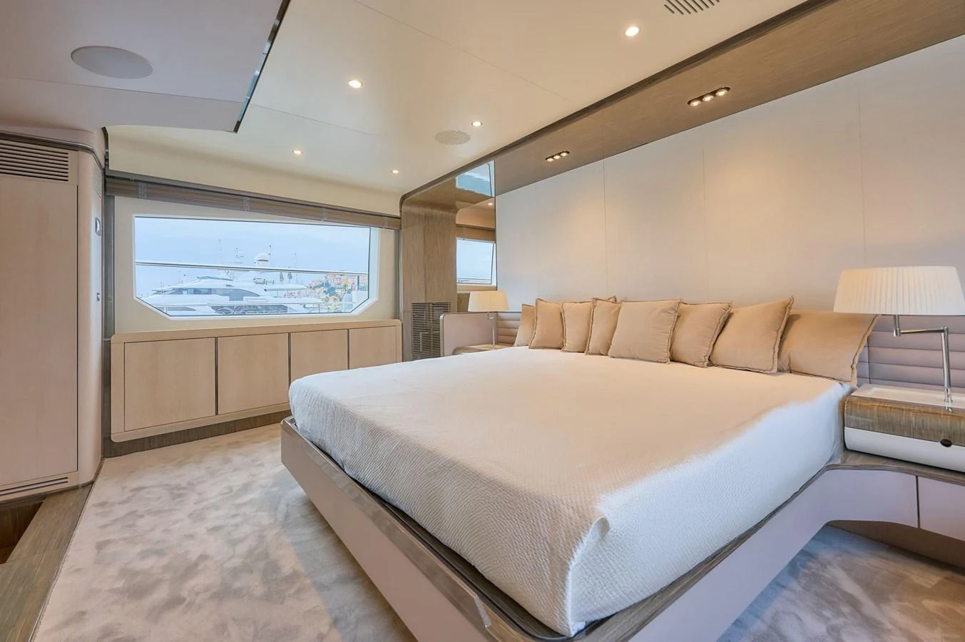 The master stateroom features a spacious bed with elegant furnishings and a large window offering a serene view. aboard SUN & SEA Yacht for Sale