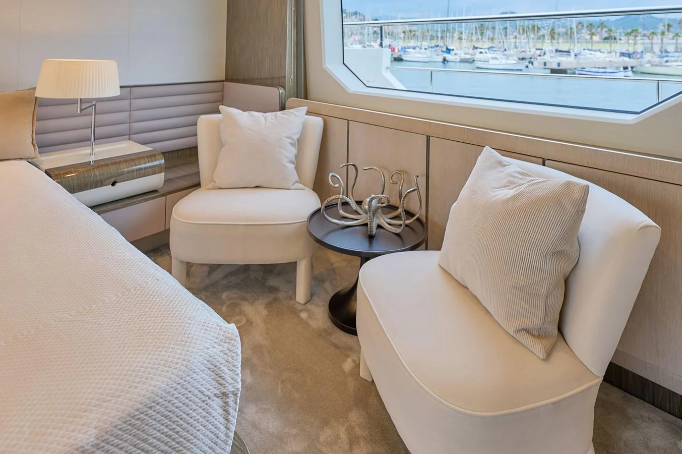 The stateroom features plush seating and a large window offering a view of the marina. aboard SUN & SEA Yacht for Sale
