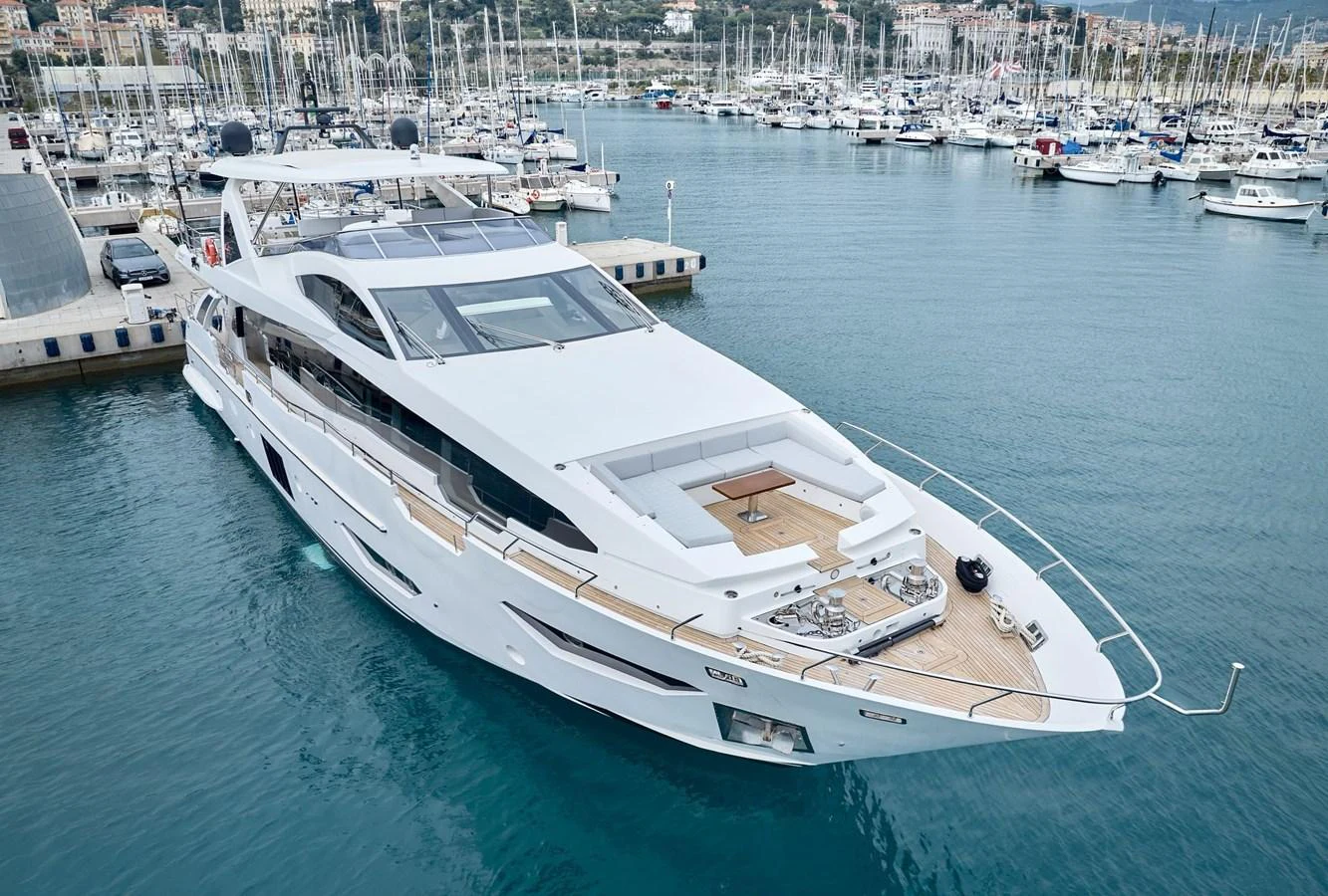 A sleek and modern yacht docked at a marina, showcasing its elegant design and spacious deck areas. aboard SUN & SEA Yacht for Sale