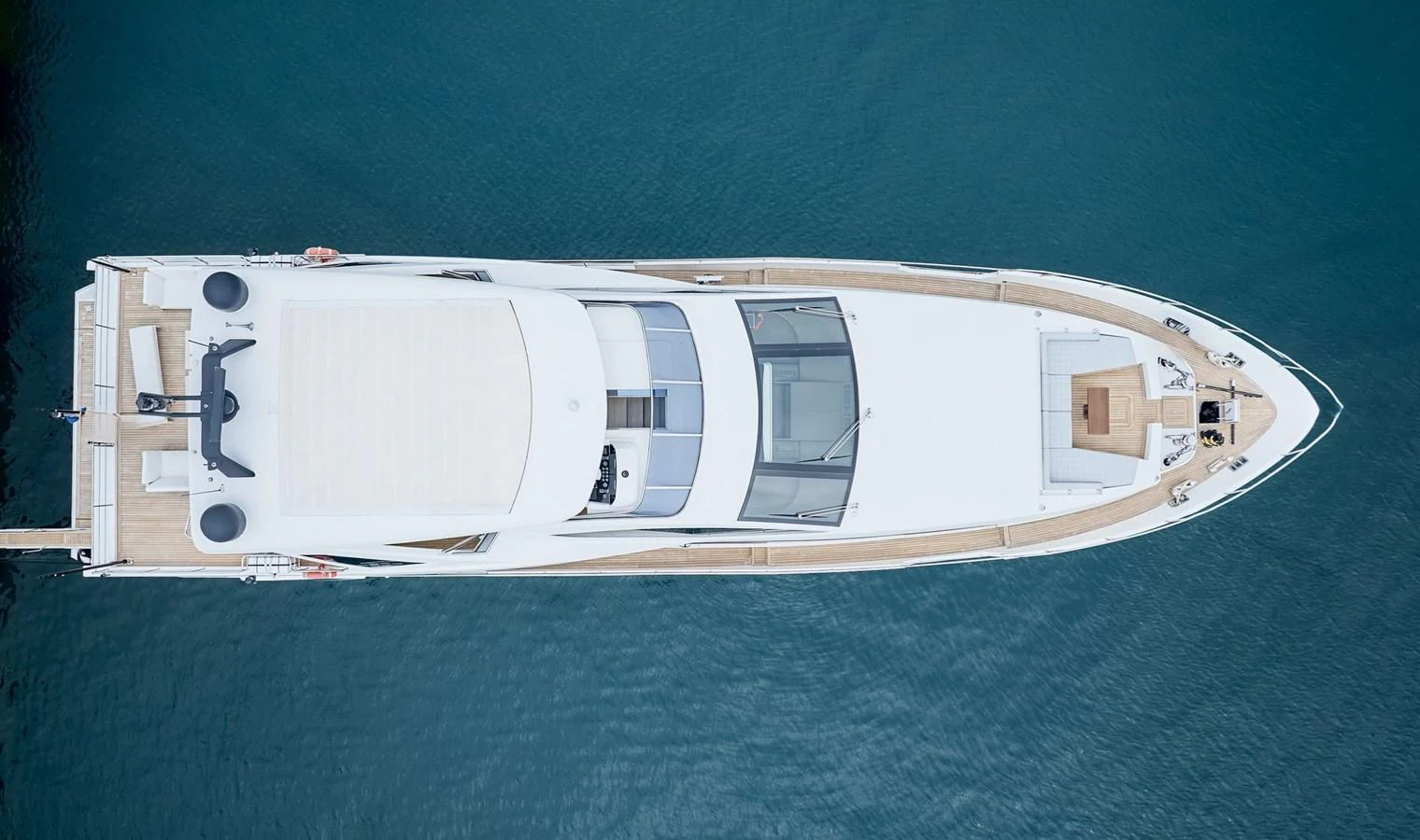 A sleek and modern yacht is captured from an aerial perspective, showcasing its elegant design and spacious deck areas. aboard SUN & SEA Yacht for Sale
