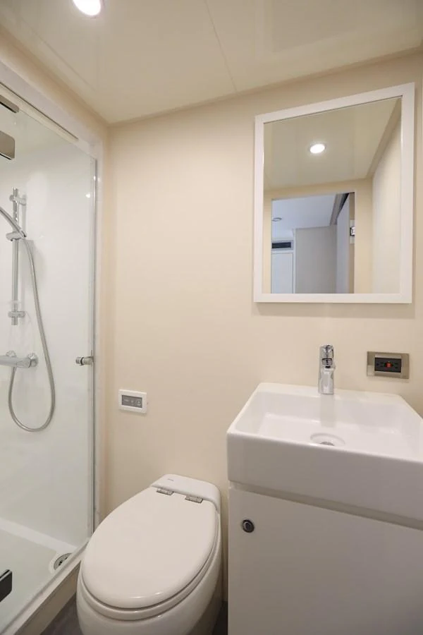 The yacht's bathroom features a modern shower, toilet, and sleek sink. aboard OCEAN ALEXANDER 28L Yacht for Sale