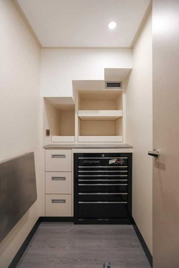A compact storage area with built-in shelves and drawers, featuring a mini-fridge. aboard OCEAN ALEXANDER 28L Yacht for Sale