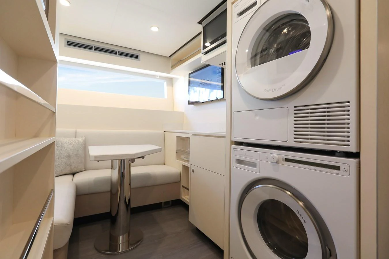 The yacht's interior features a compact and efficient laundry area with modern appliances and a cozy seating nook. aboard OCEAN ALEXANDER 28L Yacht for Sale