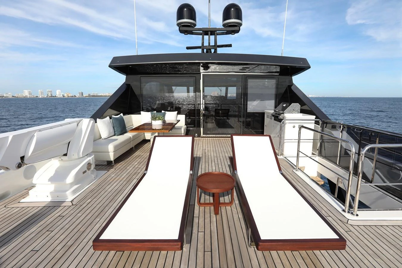 The aft deck features luxurious sun loungers and a comfortable seating area with stunning ocean views. aboard OCEAN ALEXANDER 28L Yacht for Sale
