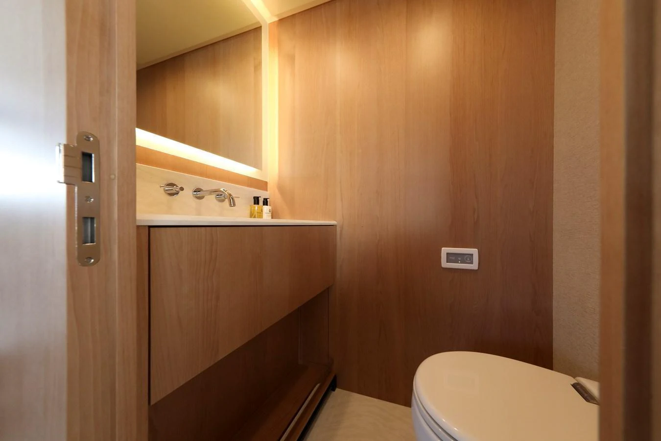 The yacht's bathroom features sleek wooden cabinetry and modern fixtures. aboard OCEAN ALEXANDER 28L Yacht for Sale