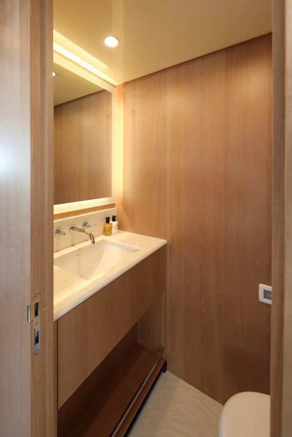 A sleek and modern bathroom with wooden paneling and a well-lit vanity area. aboard OCEAN ALEXANDER 28L Yacht for Sale