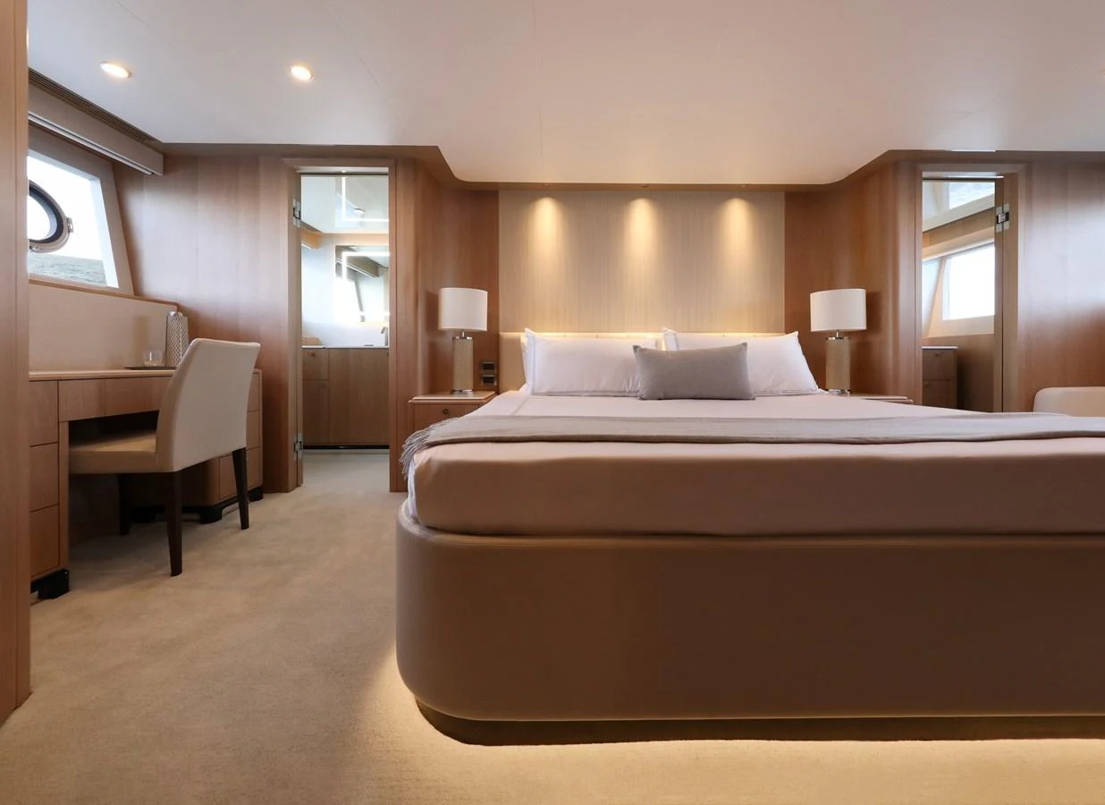The master stateroom features a luxurious bed with elegant lighting and ample natural light from large windows. aboard OCEAN ALEXANDER 28L Yacht for Sale