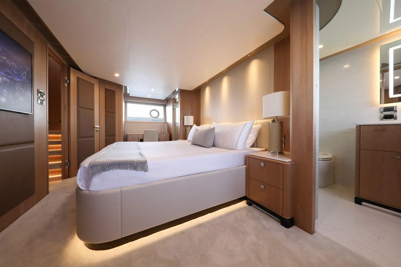 The master stateroom features a spacious bed, elegant wood finishes, and modern lighting. aboard OCEAN ALEXANDER 28L Yacht for Sale
