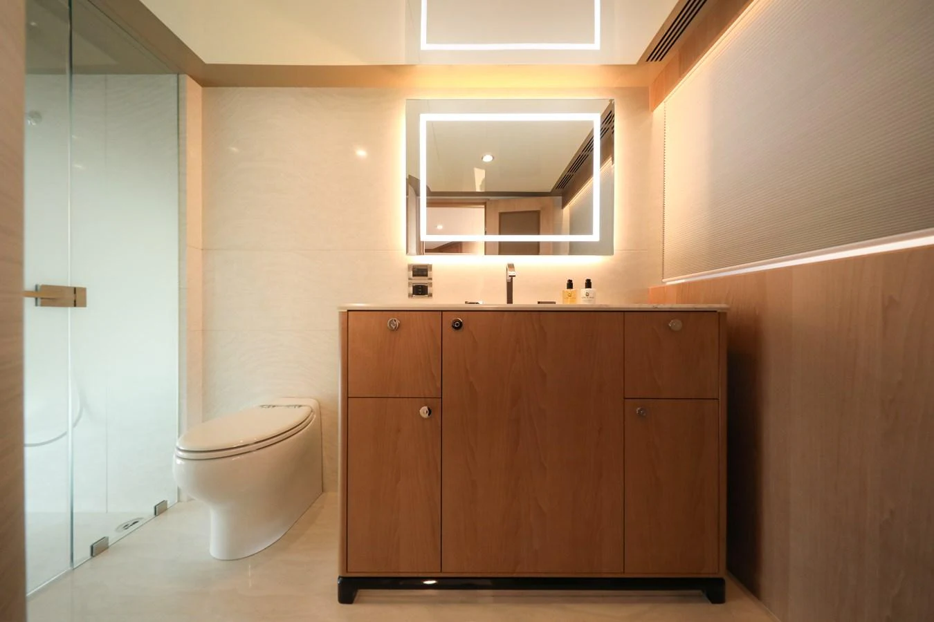A modern and elegant yacht bathroom featuring a sleek vanity and a glass-enclosed shower. aboard OCEAN ALEXANDER 28L Yacht for Sale