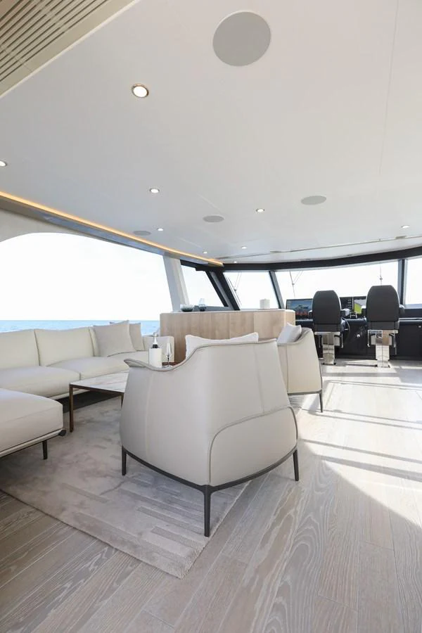 The salon features modern furnishings with ample natural light and a view of the helm station. aboard OCEAN ALEXANDER 28L Yacht for Sale