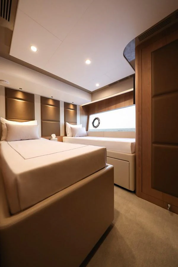 A cozy guest stateroom featuring twin beds and a large window for natural light. aboard OCEAN ALEXANDER 28L Yacht for Sale