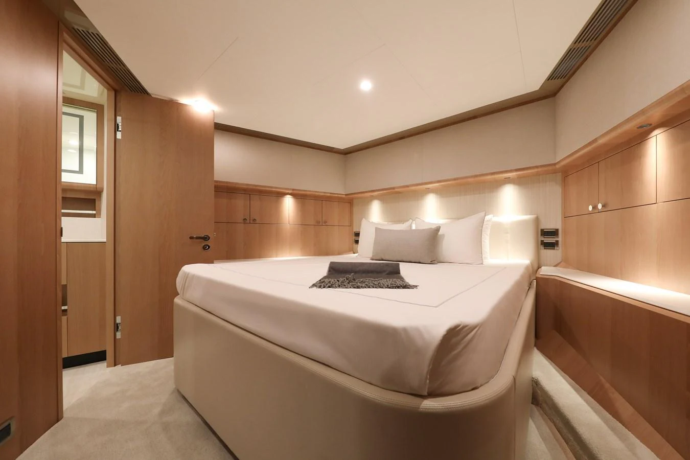 The stateroom features a plush bed with elegant wood paneling and soft lighting. aboard OCEAN ALEXANDER 28L Yacht for Sale