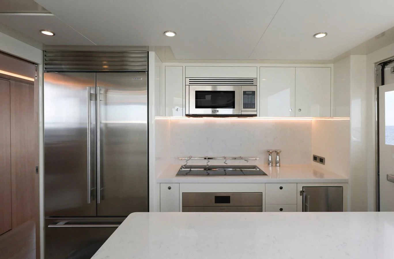 The modern galley features sleek stainless steel appliances and a pristine white countertop. aboard OCEAN ALEXANDER 28L Yacht for Sale