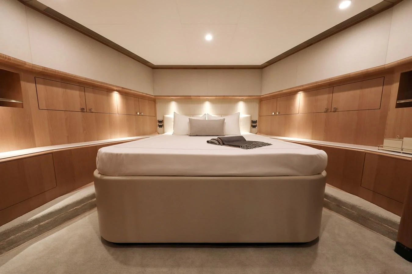 The master stateroom features a spacious bed with elegant wood paneling and ambient lighting. aboard OCEAN ALEXANDER 28L Yacht for Sale