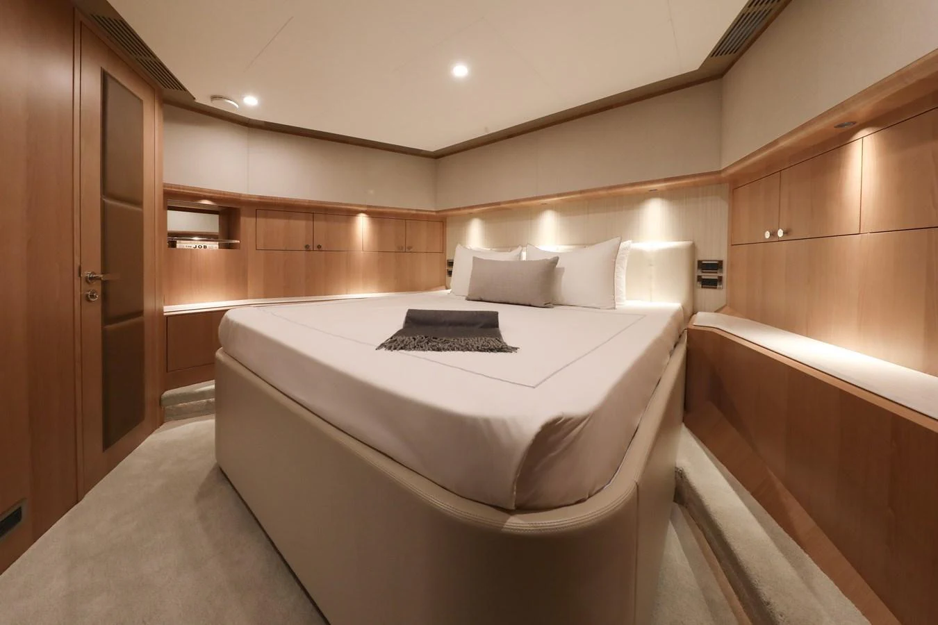 The stateroom features a luxurious bed with elegant wood paneling and soft lighting. aboard OCEAN ALEXANDER 28L Yacht for Sale