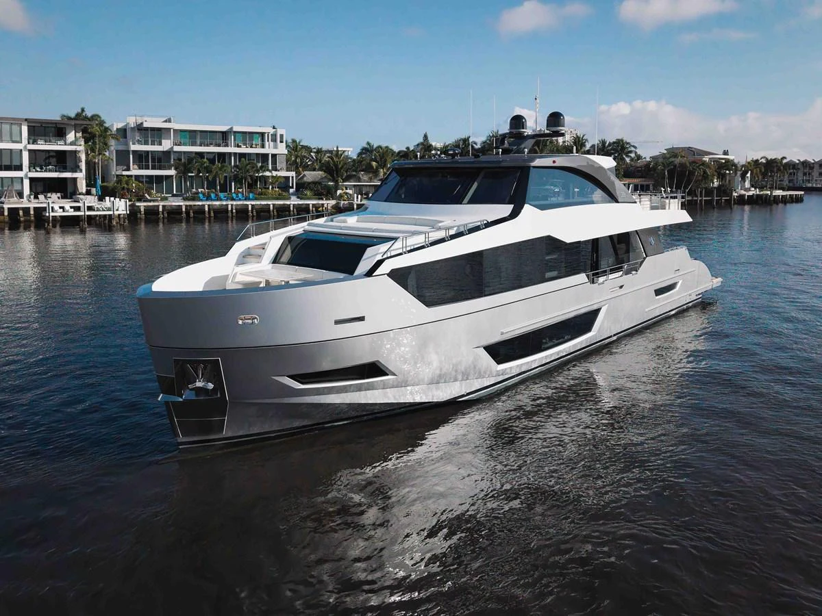 A sleek and modern yacht cruising through calm waters with a luxurious waterfront backdrop. aboard CHAOS Yacht for Sale