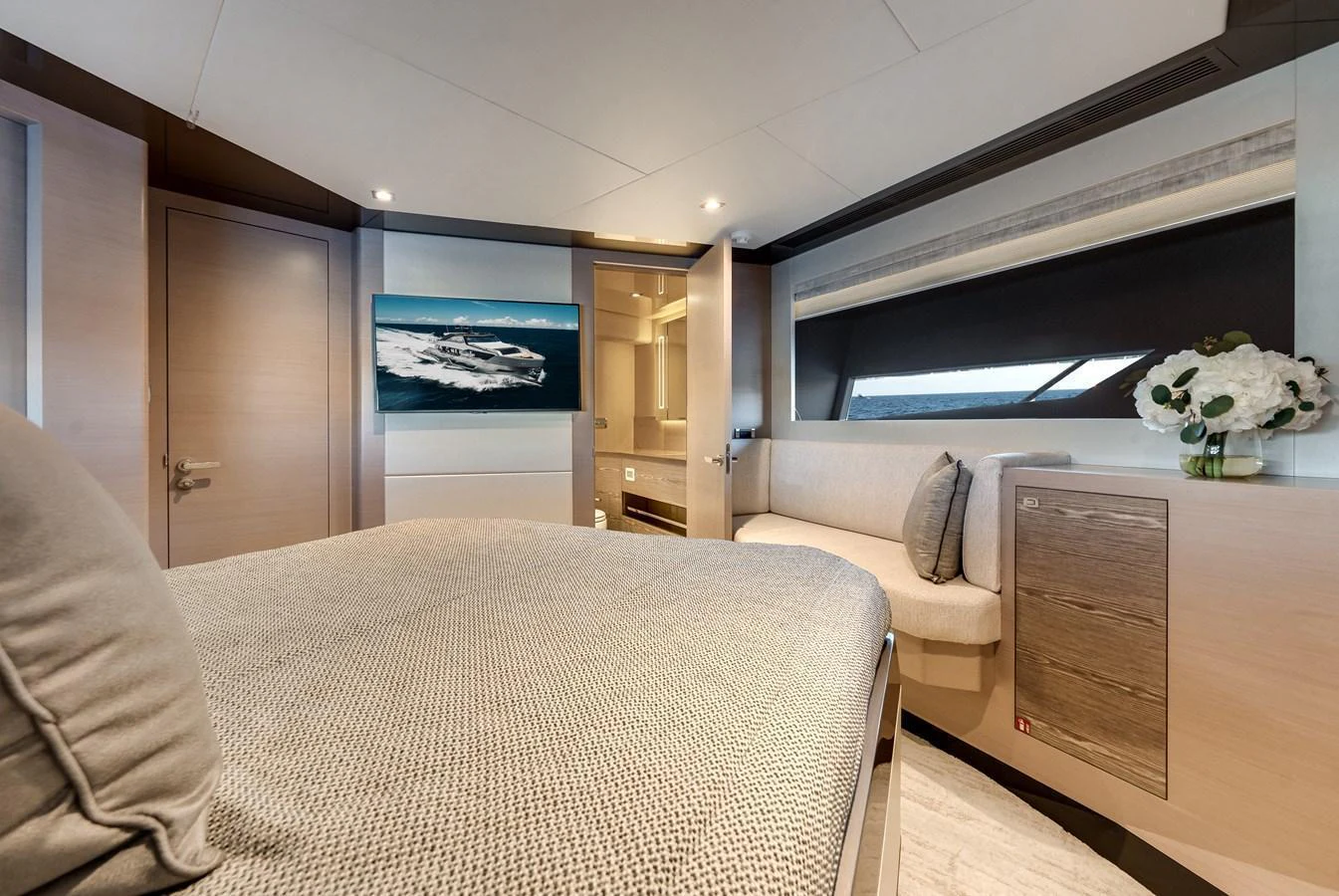 A luxurious stateroom featuring a comfortable bed, modern decor, and ample natural light. aboard CHAOS Yacht for Sale