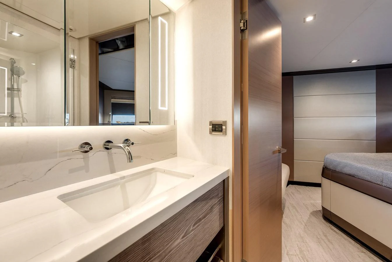 The yacht's bathroom features modern fixtures and a sleek design, leading into a cozy bedroom. aboard CHAOS Yacht for Sale