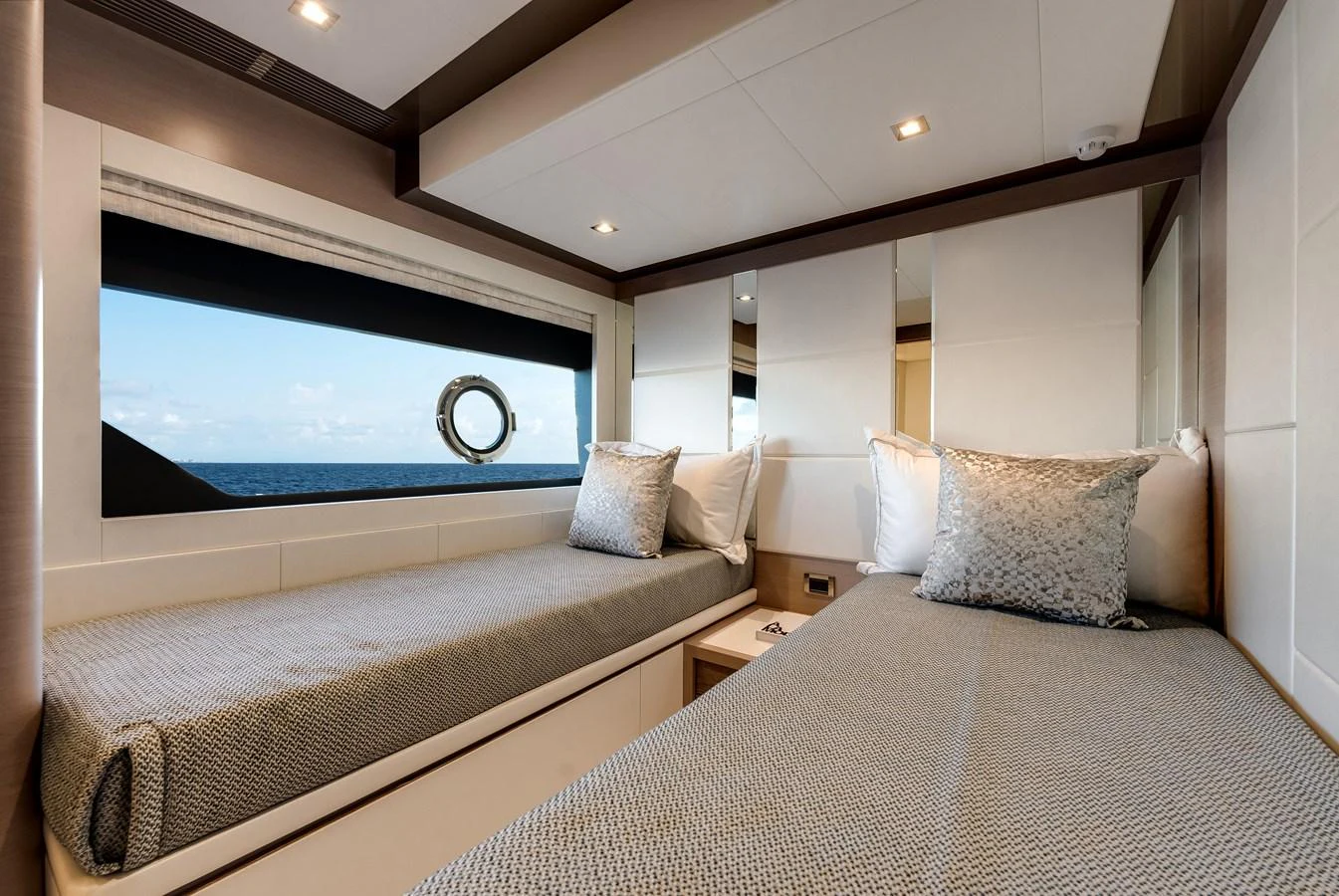 The guest stateroom features two twin beds with a large window offering a view of the sea. aboard CHAOS Yacht for Sale