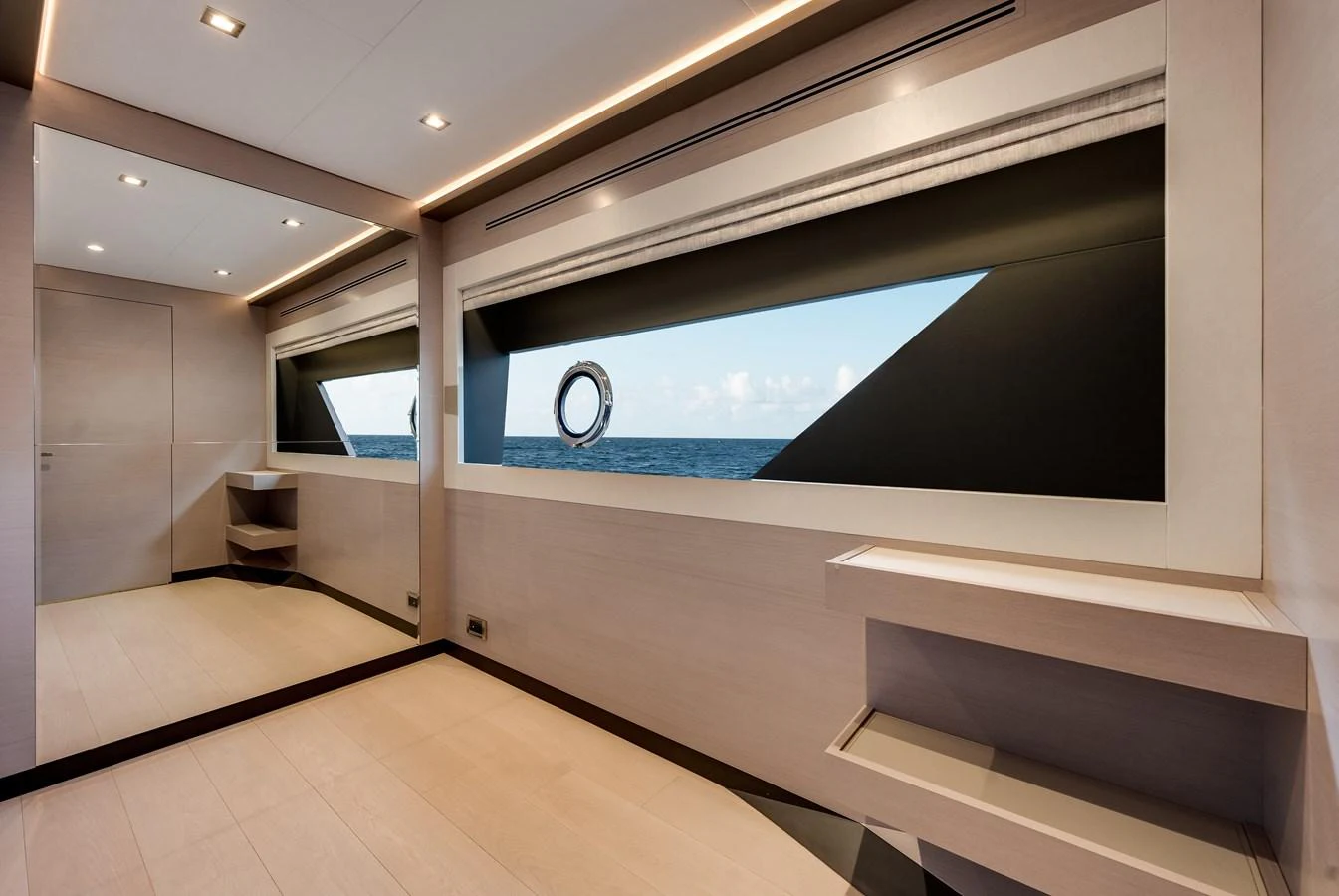 A modern and spacious interior room with large windows offering a view of the sea. aboard CHAOS Yacht for Sale