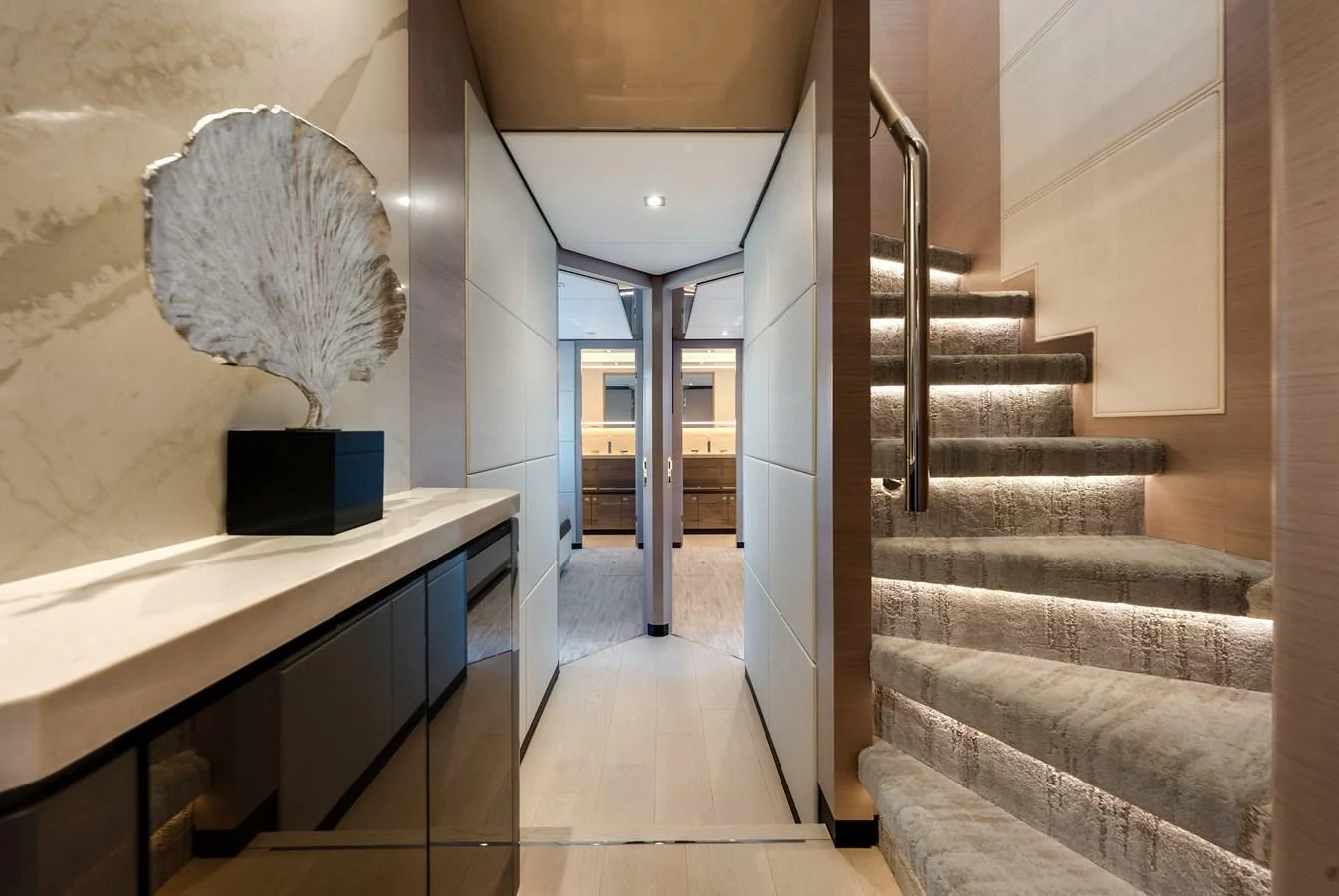A luxurious interior hallway with modern decor and a staircase leading to the upper deck. aboard CHAOS Yacht for Sale