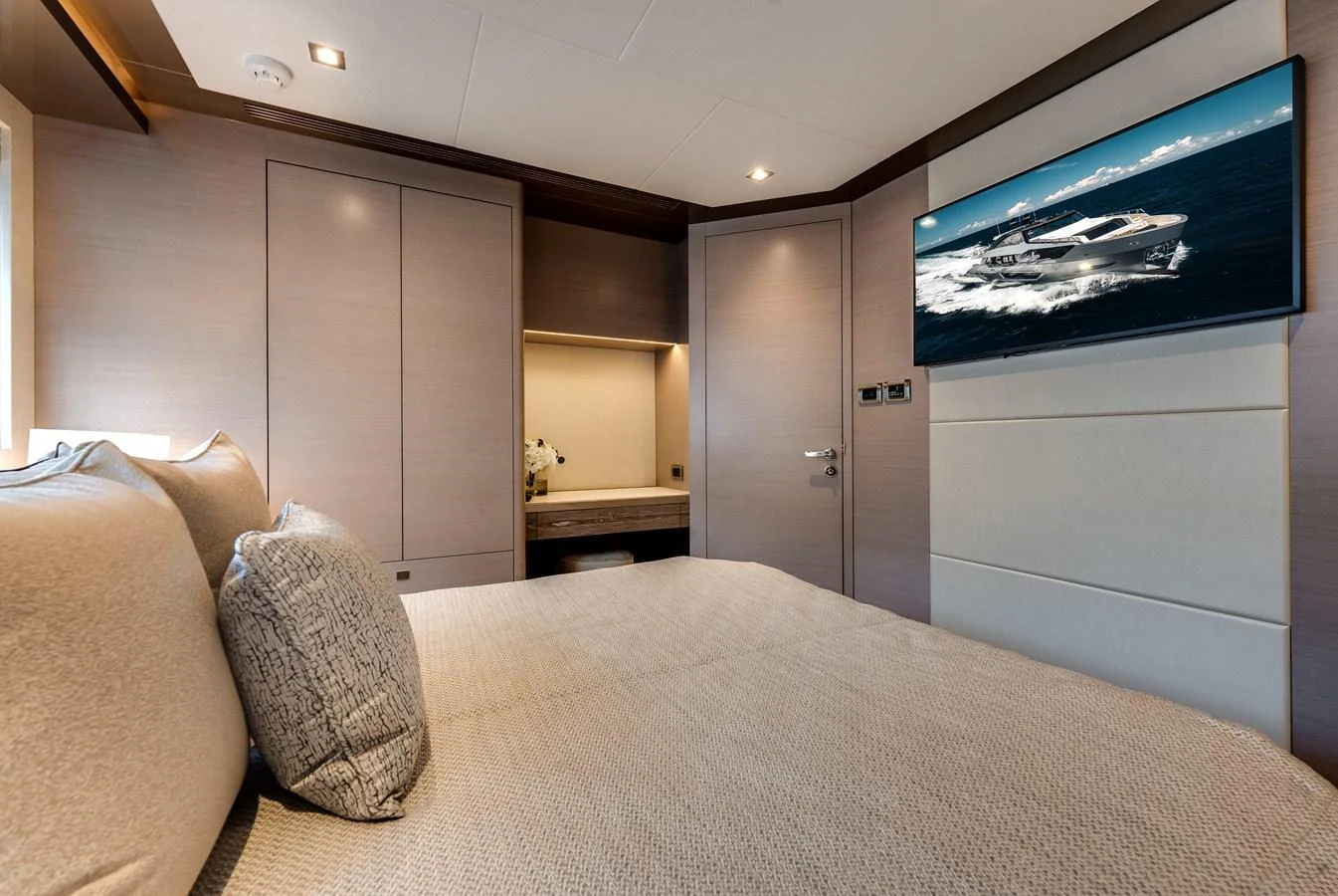 The stateroom features a comfortable bed, modern decor, and a wall-mounted TV. aboard CHAOS Yacht for Sale