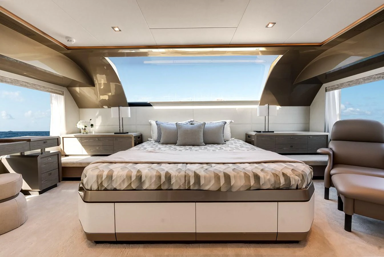 The master stateroom features a luxurious bed with panoramic views through large windows. aboard CHAOS Yacht for Sale