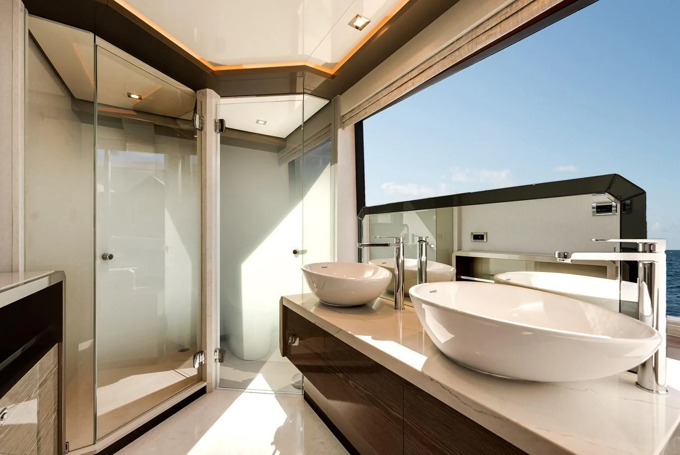 The yacht's bathroom features modern fixtures and a large window with an ocean view. aboard CHAOS Yacht for Sale