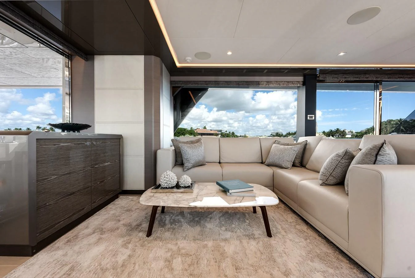 The salon features a luxurious seating area with a modern, elegant design and large windows offering stunning views. aboard CHAOS Yacht for Sale