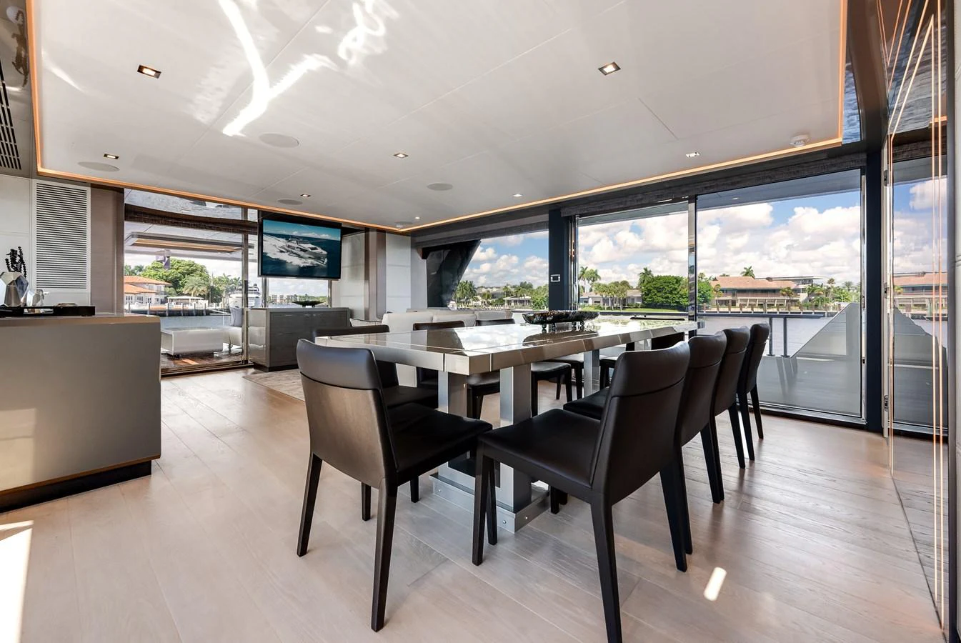 The yacht's dining area features a sleek, modern design with ample natural light and stunning views. aboard CHAOS Yacht for Sale