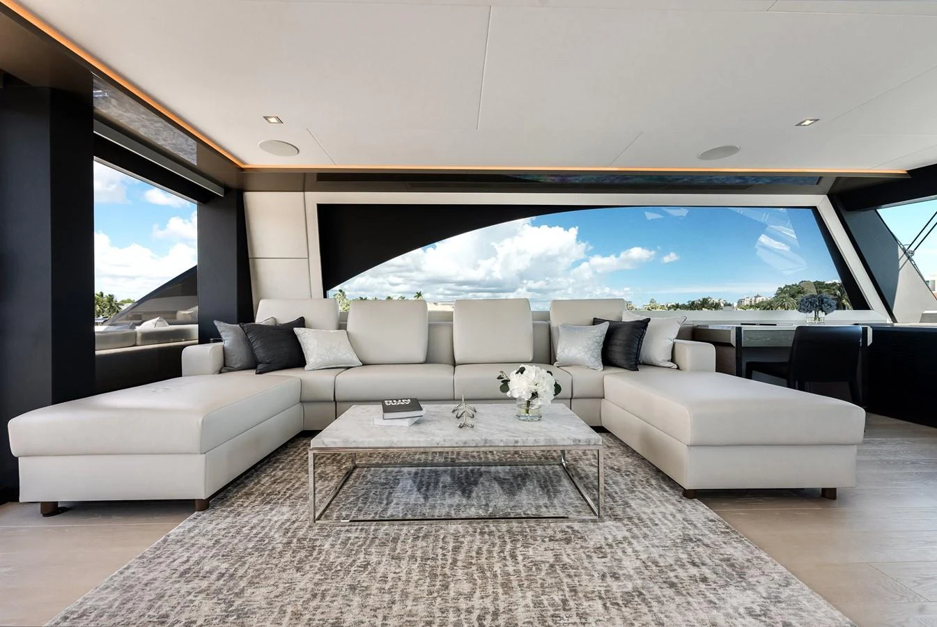 The salon features a spacious and elegant seating area with panoramic windows offering stunning views. aboard CHAOS Yacht for Sale