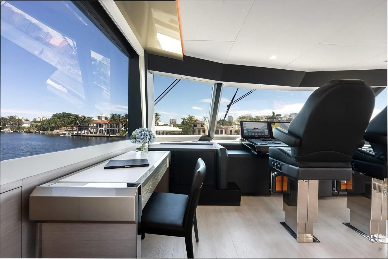 The helm area features modern seating and a sleek desk with a view of the water. aboard CHAOS Yacht for Sale